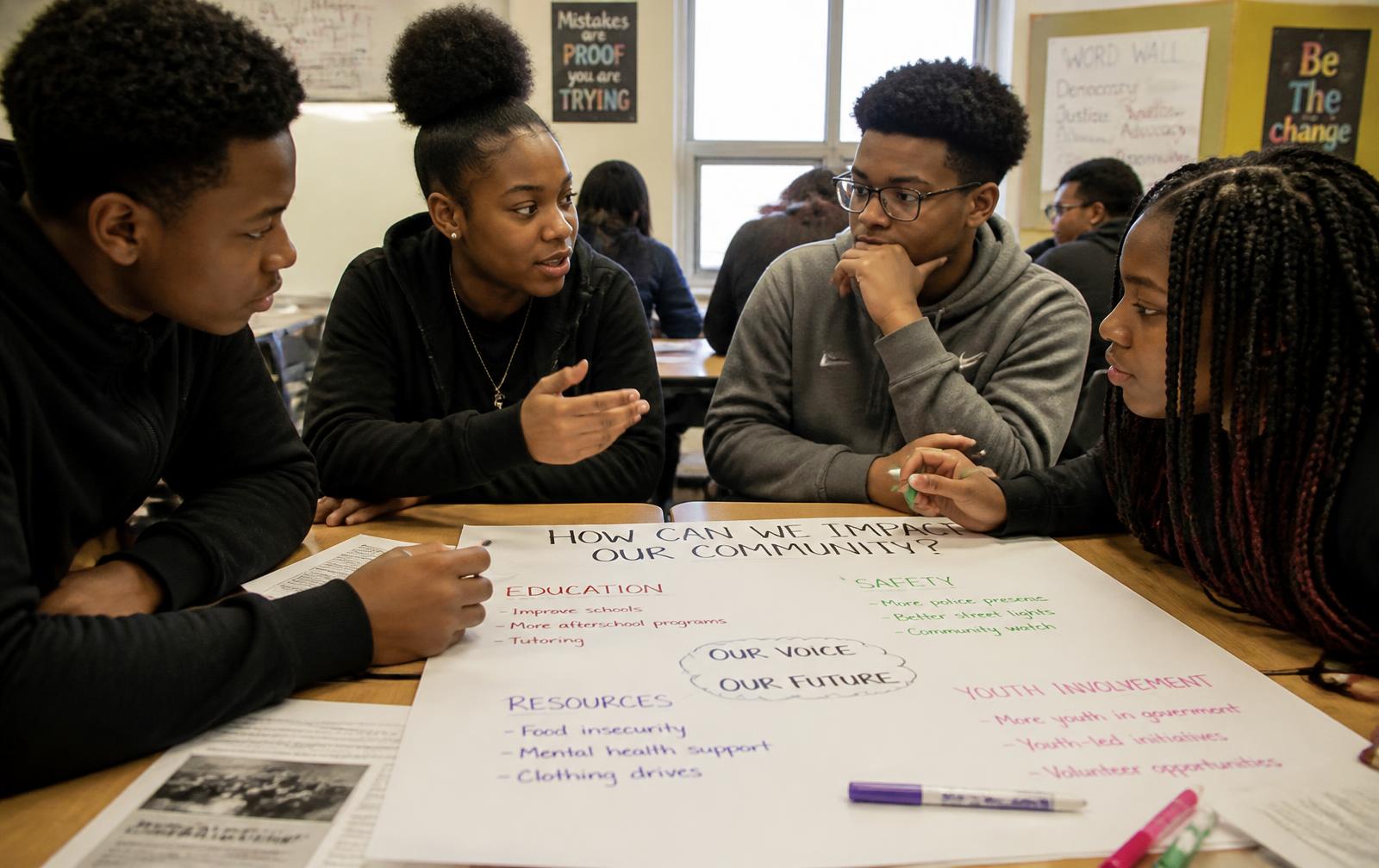 Black middle and high school students collaborating on a civics project around a table